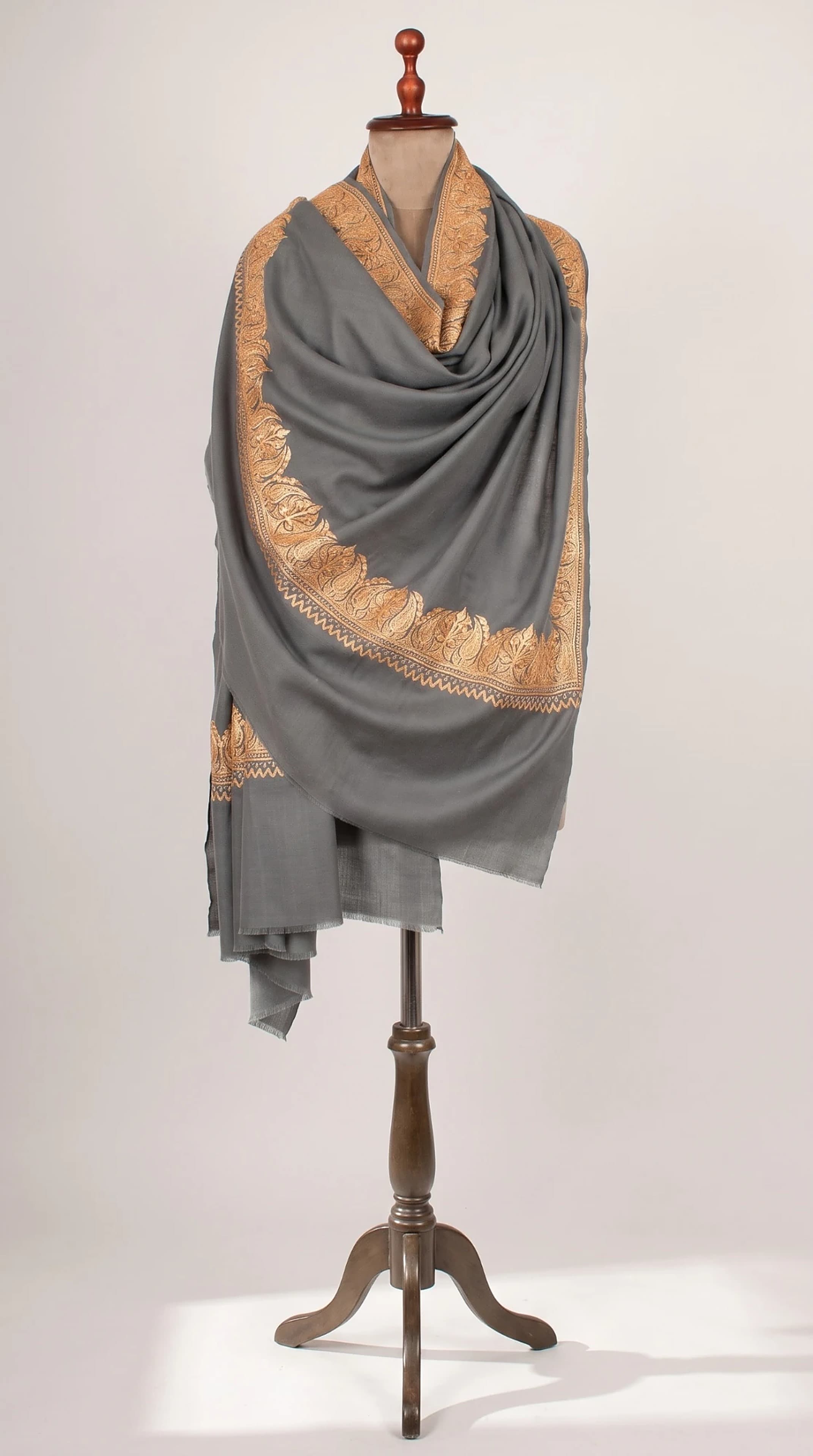 Grey shawl with gold embroidered border on a mannequin